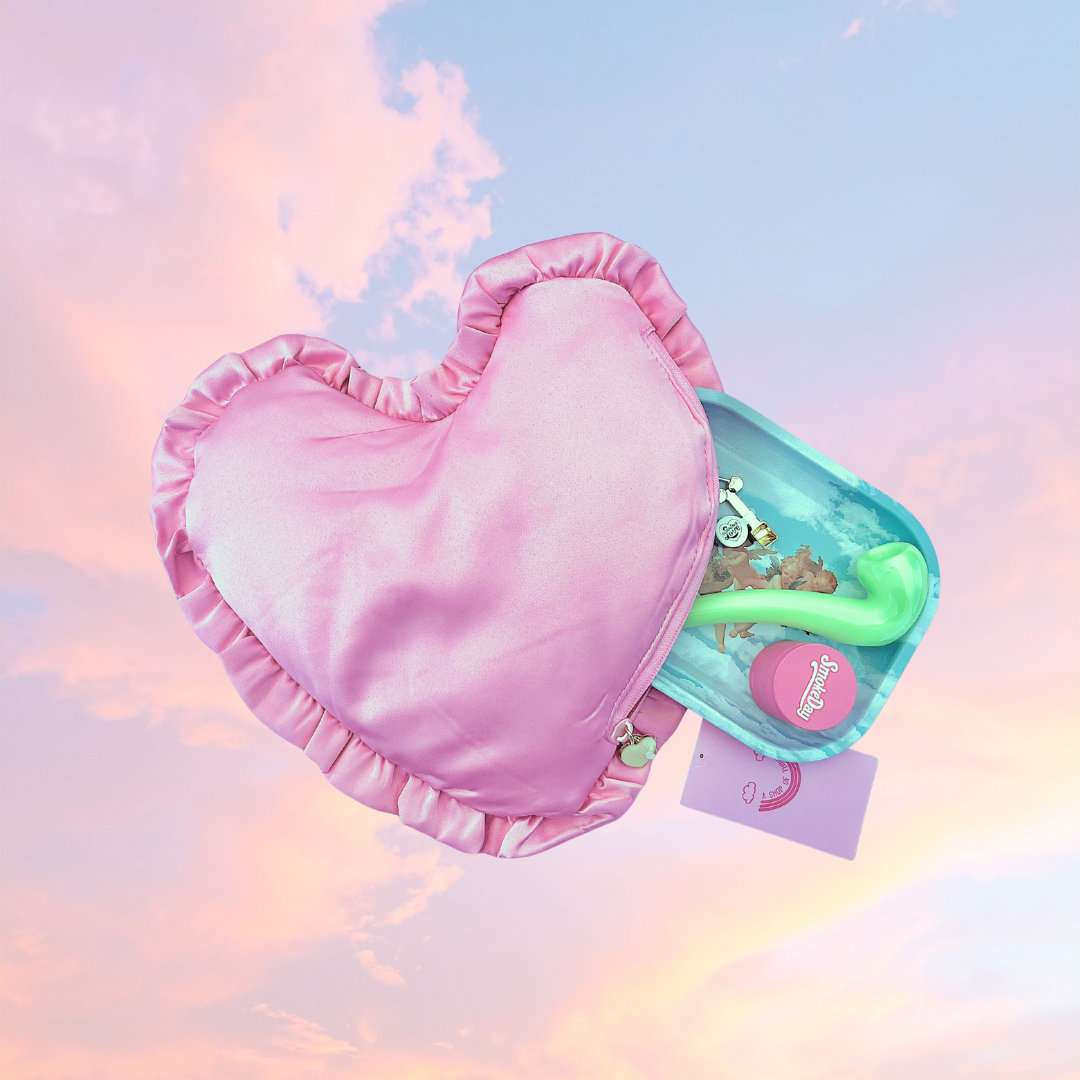 Heart-shaped pink Smell-proof bag with a green smoking pipe and other smoking accessories on a pastel background